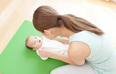 赤ちゃんの顔を見て接する女性