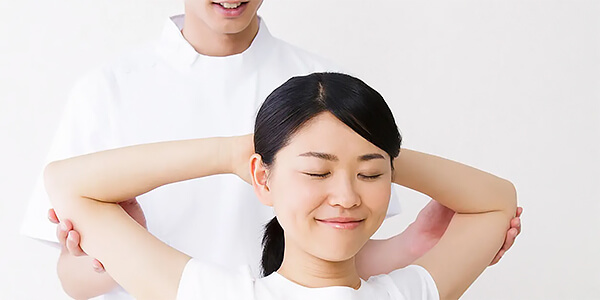 肩から腕のストレッチ施術を受ける女性