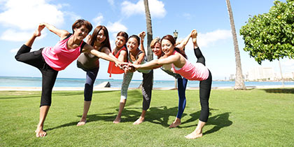 ハワイの青空の下でヨガを楽しむ女性たち